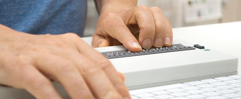 Personne travaillant sur ordinateur avec afficheur braille